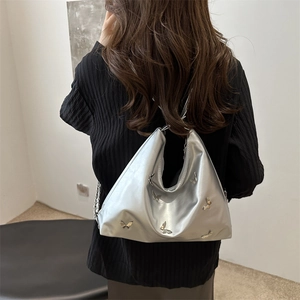 Silver hobo tote bag with butterfly metallic appliques and chain strap shown on model