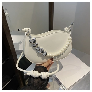 Détail du sac demi-lune blanc avec chaîne en perles et accents de cœurs argentés