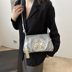 Silver satin crossbody bag with traditional floral embroidery and yellow tassel charm