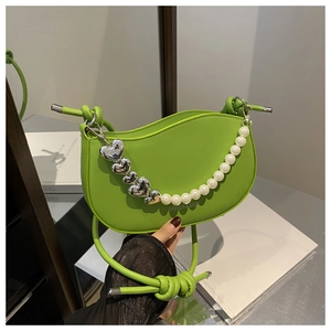Détail du sac demi-lune vert avec breloque cœur argentée et chaîne de perles