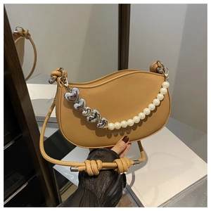 Gros plan du sac demi-lune kaki avec chaîne en perles et pendentif cœur argenté