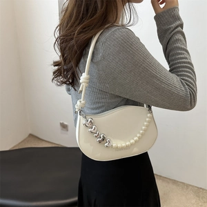 Sac à bandoulière blanc en demi-lune avec perles et chaîne de cœurs sur modèle