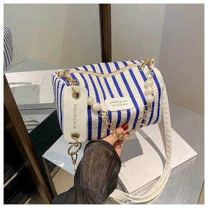 Détail du sac cylindrique à rayures bleues et blanches avec chaîne en perles