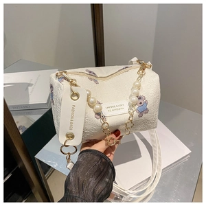 Détail du sac cylindrique blanc avec texture plissée 3D et motif d'ours violet