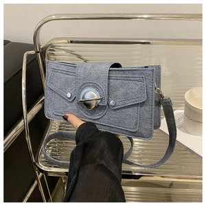 Détail du sac bandoulière bleu clair avec fermoir rotatif en métal et coutures enveloppe