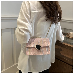 Detail of pink shoulder bag with geometric embossing, vertical embroidery, and gold chain