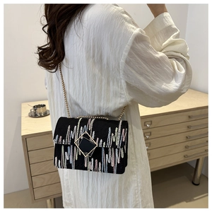 Lifestyle view showing the size and fit of the embroidered chain shoulder bag on a model