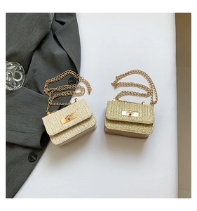 Detail of woven straw crossbody bags with gold metal clasps and chain straps