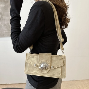 Sac bandoulière rétro en toile kaki avec boucle métallique porté par un mannequin