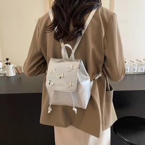 Metallic silver mini butterfly backpack with 3D accents and drawstring closure