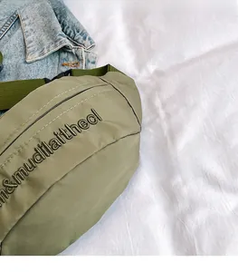 Close-up of military green nylon crossbody bag with letter embroidery and plastic buckle