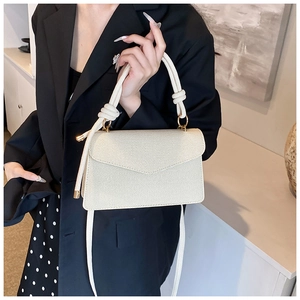 Detail of off-white woven texture shoulder bag featuring thick rope handle and metal buckle