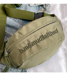 Detailed close-up of army green crossbody bag featuring letter embroidery and nylon texture