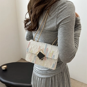 White monogrammed shoulder bag with colorful embroidery and golden chain strap