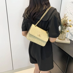 Beige woven crossbody bag with gold chain strap and herringbone straw texture for summer