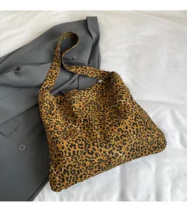 Detailed close-up of leopard print canvas tote bag on grey blazer for a casual look