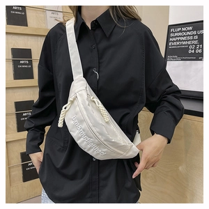 Detail of off-white nylon chest bag with embroidery and adjustable woven strap