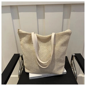 Dettaglio borsa tote intrecciata color crema con maglia traforata e spalline in pelle