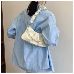 Détail du sac sous le bras plissé blanc cassé avec chaîne en perles et bandoulière à nœud