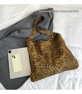 Size comparison of leopard print tote bag with a phone and tablet showing large capacity