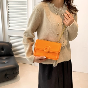 Fashionable bright orange patent leather crossbody bag with elegant gold chain strap