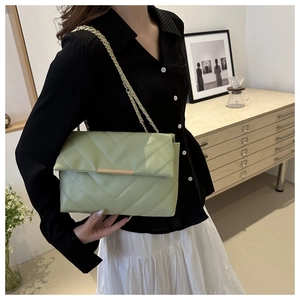 Detail of sage green crossbody bag with V-quilted faux leather and gold chain strap