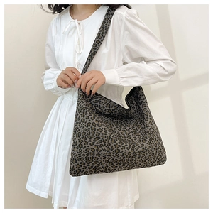 Hobo style tote bag featuring dense leopard print and wide shoulder strap detail