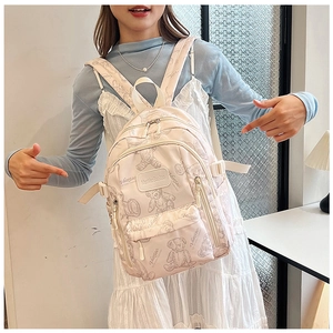 Detail of nylon school backpack featuring cute bear patterns and side buckle straps