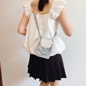 Mini sac bandoulière argenté pour femme avec texture métallique porté par un mannequin