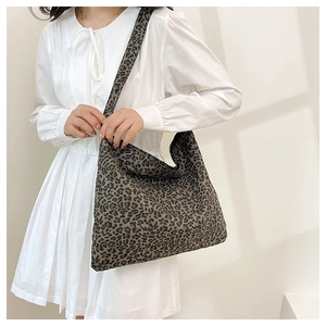 Leopard print canvas tote bag shown with shoulder strap on a model for daily use