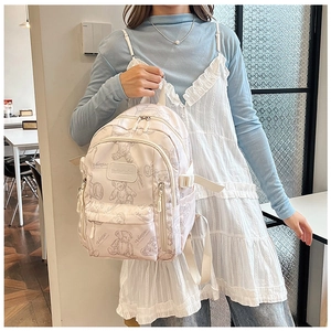 Detail of a lightweight backpack featuring a retro teddy bear print and side pockets