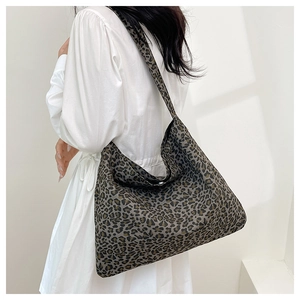 Detailed view of oversized leopard print tote bag on shoulder with natural lighting