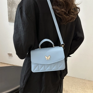 Chic light blue quilted crossbody bag with metal butterfly clasp and top handle