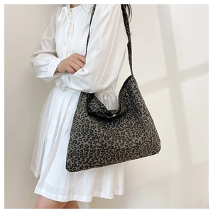 Detail of large leopard print tote bag with soft fabric texture and wide shoulder strap