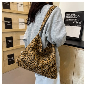 Detailed view of a large leopard print tote bag styled on a person in a casual setting
