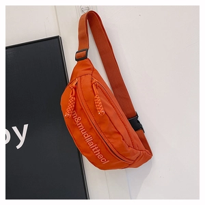 Detail of vibrant orange nylon chest bag featuring white letter embroidery and zip closure