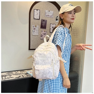 Close-up of white school backpack with gray bear pattern and adjustable side straps