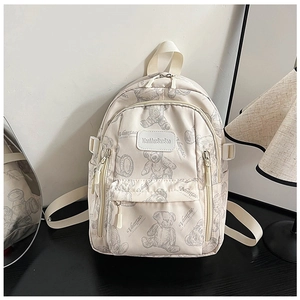 Close-up of beige school backpack with bear prints and front zipper pocket detail