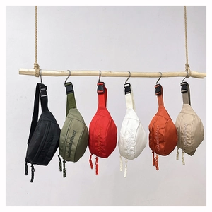 Detailed display of assorted colorful nylon crossbody bags hanging on a rustic wooden bar