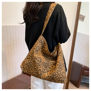 Detail of a large leopard print tote bag shown on a shoulder in a lifestyle setting