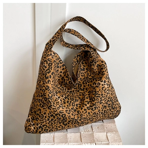 Close-up of leopard print canvas tote bag with wide strap on marble display