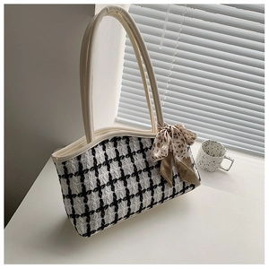 Close-up of black and white tweed tote bag featuring leopard print scarf and leather handles