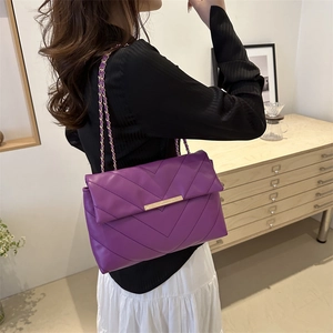 Minimalist purple quilted crossbody bag with golden chain strap and metal bar lock