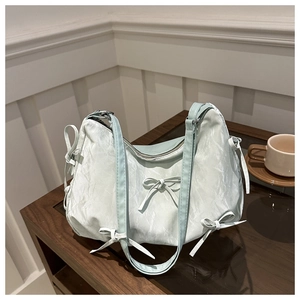 Détail du sac cabas vert menthe en tissu plissé souple avec des nœuds décoratifs