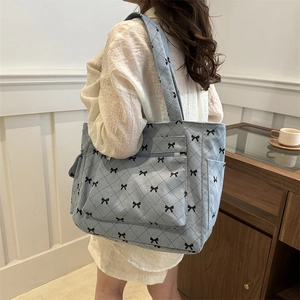 Blue corduroy tote bag with black bow patterns and quilted design for daily casual use