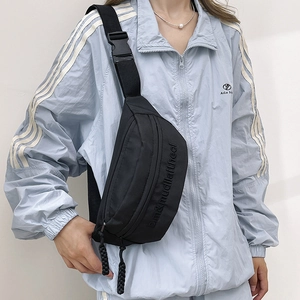 Minimalist black nylon crossbody chest bag with embossed lettering and adjustable strap