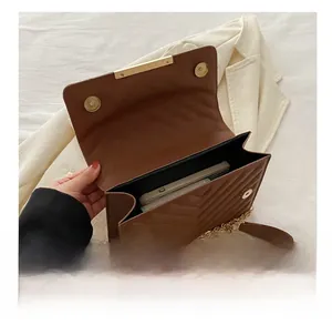 Detail view of the brown quilted crossbody bag showing interior storage capacity for a phone