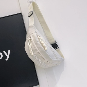 Detail of adjustable strap with plastic buckle and mudilaithed logo on cream crossbody bag