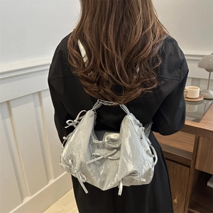 Sac à bandoulière argenté métallisé avec détails de nœuds et texture plissée moderne