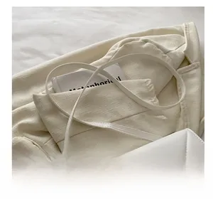 Detail of white geometric quilted leather shoulder bag with fine strap and gold hardware